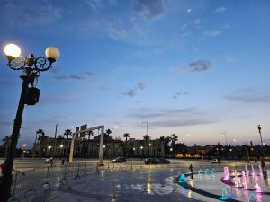 a plaza with a street light and water fountain at appartement in Oujda