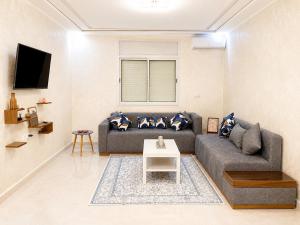 a living room with a couch and a table at appartement in Oujda