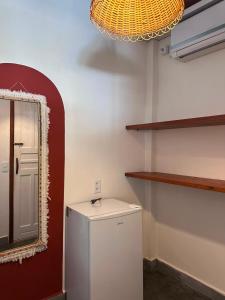 a bathroom with a white refrigerator and a mirror at Refugá in Porto Seguro +24 photos
