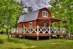a red cabin with a porch in the grass at Ocoee Cottage Water Front in Copperhill