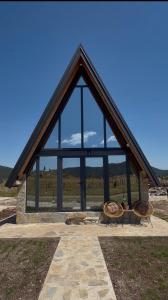 a large glass building with two benches in front of it at Hedwig cottages 1 in Njegovuđa