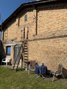 a brick building with a table and chairs and a ladder at Landhaus Settin 