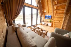 a living room with a couch and a large window at Hedwig cottages 1 in Njegovuđa