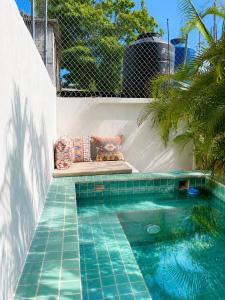 a swimming pool with a bench next to a swimming pool at Casa Coconut in Puerto Escondido