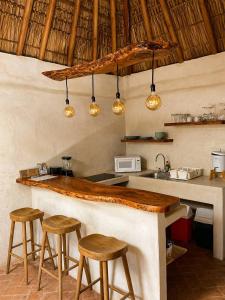 a kitchen with a bar with stools and a sink at Casa Coconut in Puerto Escondido