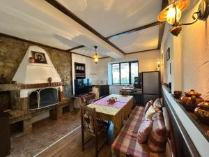 a living room with a table and a fireplace at Къща за гости "При Примо" in Zlatograd
