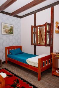 a bedroom with a bed with a wooden frame and blue sheets at Izletište Ružić in Mrčajevci
