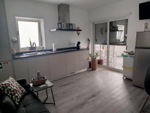 a living room with a couch and a kitchen at Casa do Ginjão in Alcobaça