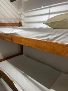 a bunk bed with white sheets and a pillow at Casa Art Maison Recife in Recife