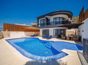 a house with a large swimming pool in front of it at Villa Ocak 1 in Kaş