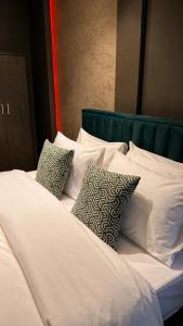 a white bed with four pillows on it at The Skyline Suite in Florina