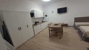a room with a kitchen and a table and a bed at Korczakówka in Szczytno