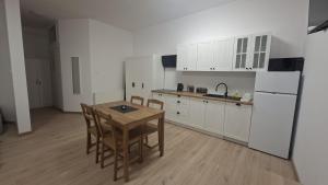 a kitchen with white cabinets and a table and chairs at Korczakówka in Szczytno