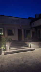 a building with stairs in front of it at night at Korczakówka in Szczytno