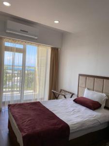 a bedroom with a bed and a large window at Gold ASSN in Cholpon-Ata
