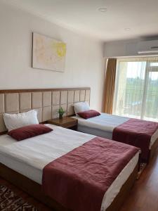 a hotel room with two beds and a window at Gold ASSN in Cholpon-Ata