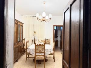a dining room with a table and chairs and a chandelier at Agriturismo Siviglia in Tocci