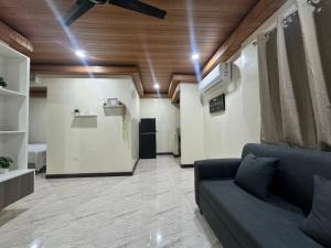 a living room with a blue couch in a room at Brian Castle in Tagum +3 photos