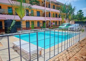 a swimming pool in front of a building at Tranquil Terrace Cottages Diani in Diani Beach