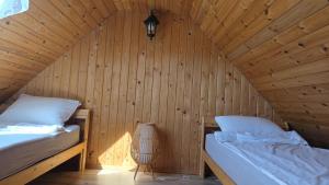 a room with two beds in a wooden cabin at Sauļuki in Ventspils