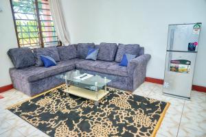 a living room with a couch and a glass table at Tranquil Terrace Cottages Diani in Diani Beach