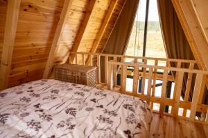 a bedroom with a bed in a log cabin at Hedwig cottages 1 in Njegovuđa