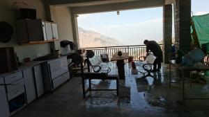 a group of people working in a kitchen with a view at Saadis cottage in Bhurban