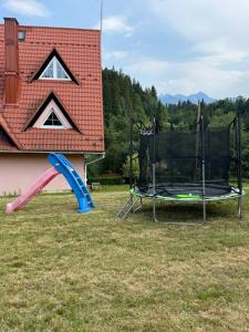 a playground with a slide and a swing at Eleni Pokoje Gościnne in Bukowina Tatrzańska