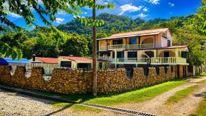 a house behind a stone wall with a fence at El Bosque in Nocaima