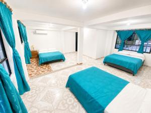 a bedroom with two beds and blue curtains at El Bosque in Nocaima +6 photos
