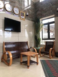 a living room with a couch and a table and clocks at Koro Guess House in Lagos