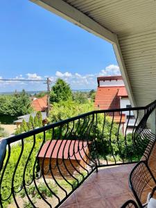 a balcony with a bench and a view of the ocean at Pelso apartman in Balatonalmádi