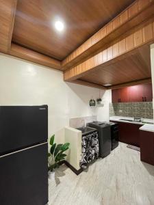 a kitchen with a sink and a black refrigerator at Brian Castle in Tagum