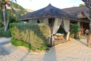 a gazebo with a grass roof on a beach at Linaw Beach Resort in Panglao