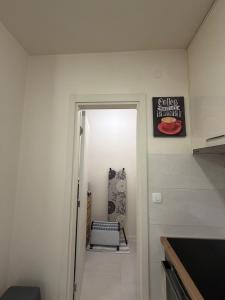 a hallway with a door to a kitchen with a chair at Apartment Central Point - Podgorica in Podgorica