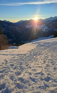 a snow covered slope with the sun in the distance at Freiheitsgefühl in Kaunerberg