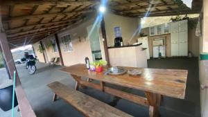 a wooden table in a kitchen with a person on a bike at Pousada flores de ipê in Capitólio
