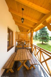 a wooden porch with a wooden table on a deck at DW KINGA Domki całoroczne 6 os z widokiem na Tatry in Kacwin +57 photos