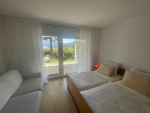 a bedroom with two beds and a large window at Apartma Loško in Cerknica