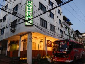 a bus is parked in front of a building at Hostal Jireh in Manta
