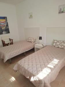 a room with two beds and a table and a chair at Cristais do Mar in Armação de Pêra