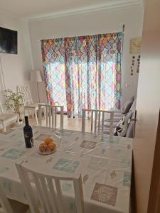 a dining room with a table with a bottle of wine at Cristais do Mar in Armação de Pêra +2 photos