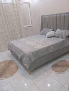 a bed in a bedroom with two mats on the floor at Grand joli F3 Draria 7P in Draria