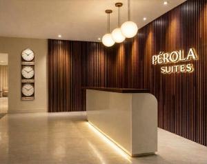 a lobby with a pocioca suites sign and clocks at Pérola Suítes Boutique Hotel in Luanda