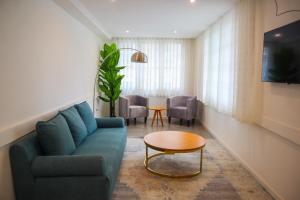a living room with a blue couch and a table at Pérola Suítes Boutique Hotel in Luanda