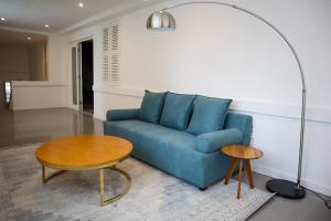 a living room with a blue couch and a table at Pérola Suítes Boutique Hotel in Luanda