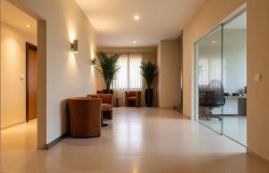 a lobby of a hospital with chairs and a tv at Pérola Suítes Boutique Hotel in Luanda
