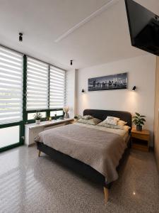 a bedroom with a large bed and a flat screen tv at Apartament w Sosnowym SPA in Serock