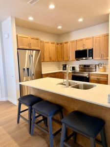 a kitchen with a large island with two stools at Desert Sun Oasis in Page