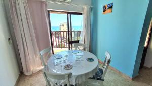 a dining room with a table with chairs and a window at Da Rocha Beach 8, SEA VIEW in Portimão